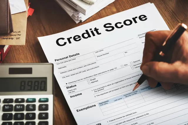 Person reviewing credit card statements and a credit utilization chart on a laptop screen