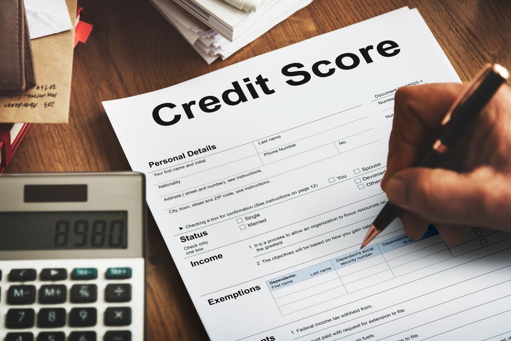 Person reviewing credit card statements and a credit utilization chart on a laptop screen