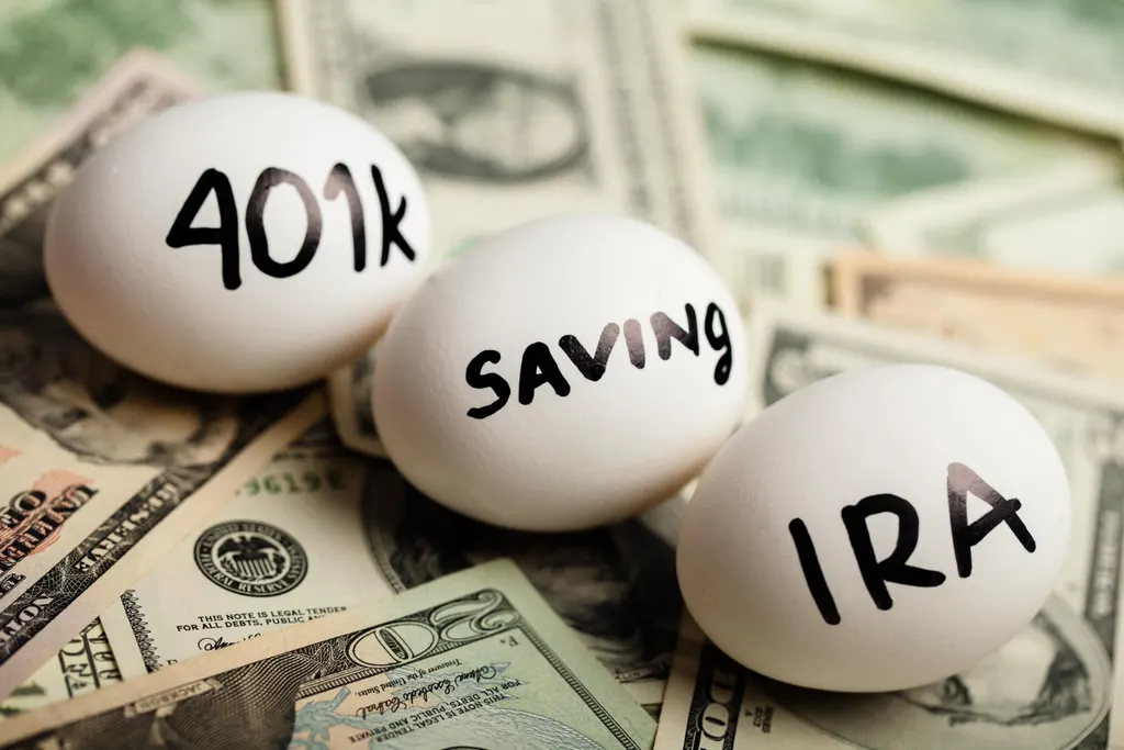 Two labeled folders on a desk comparing a 401(k) plan and an IRA account