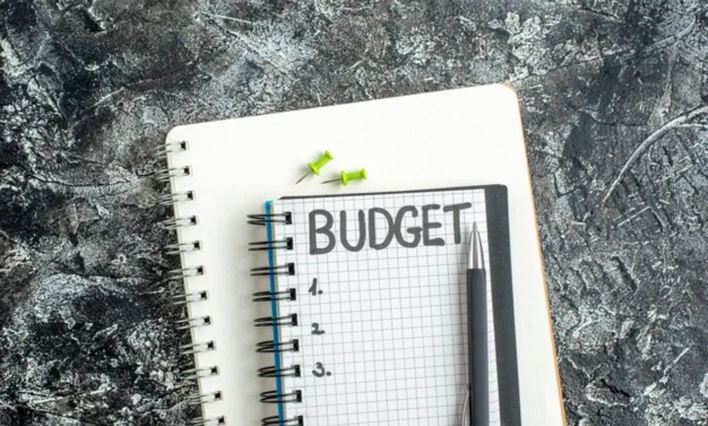 A notebook showing a monthly budget with income and expense categories listed