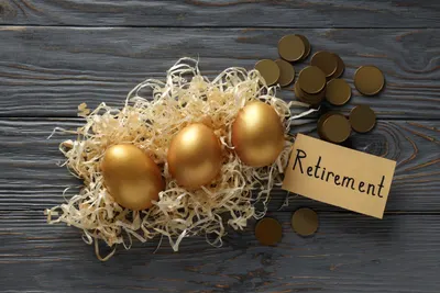 Two workers reviewing retirement plan documents comparing a pension statement and a 401(k) account balance
