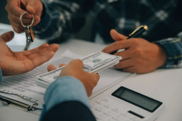 Person reviewing a 401(k) loan statement at a kitchen table with a calculator and notebook